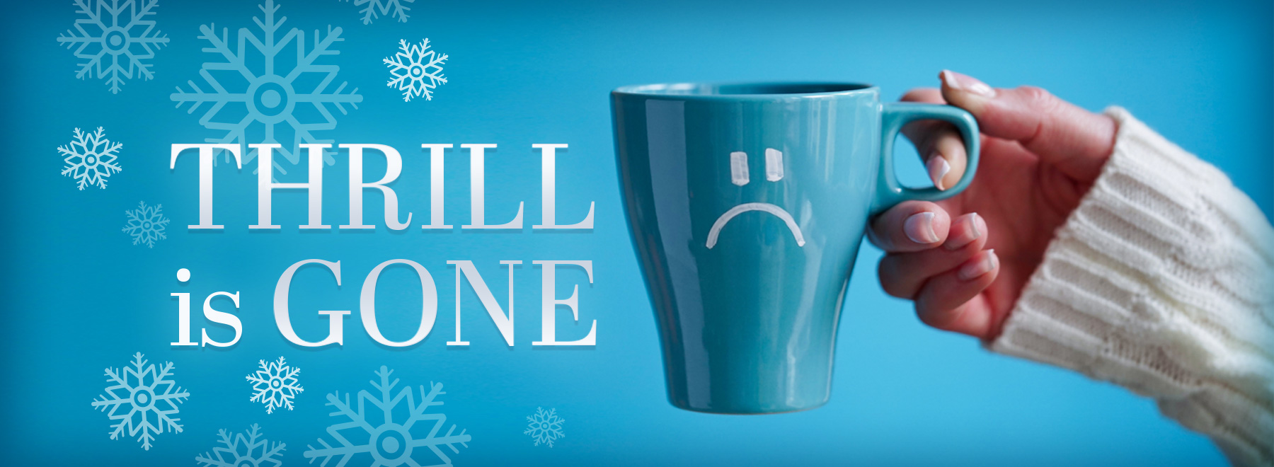 Hand holding a blue mug with frowny face